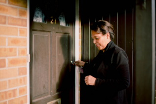 women unlocking house door
